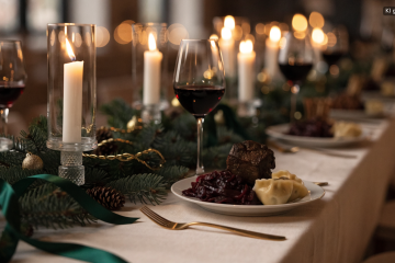 Festlich eingedeckter Tisch mit Tannenzweigen und Kerzen, Weihnachtsmenü für die Firmenfeier