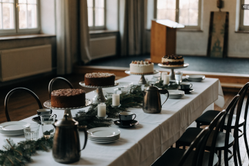 Kaffeetafel mit Kerzen und Tannengrün im Saal, Adventsfeier planen
